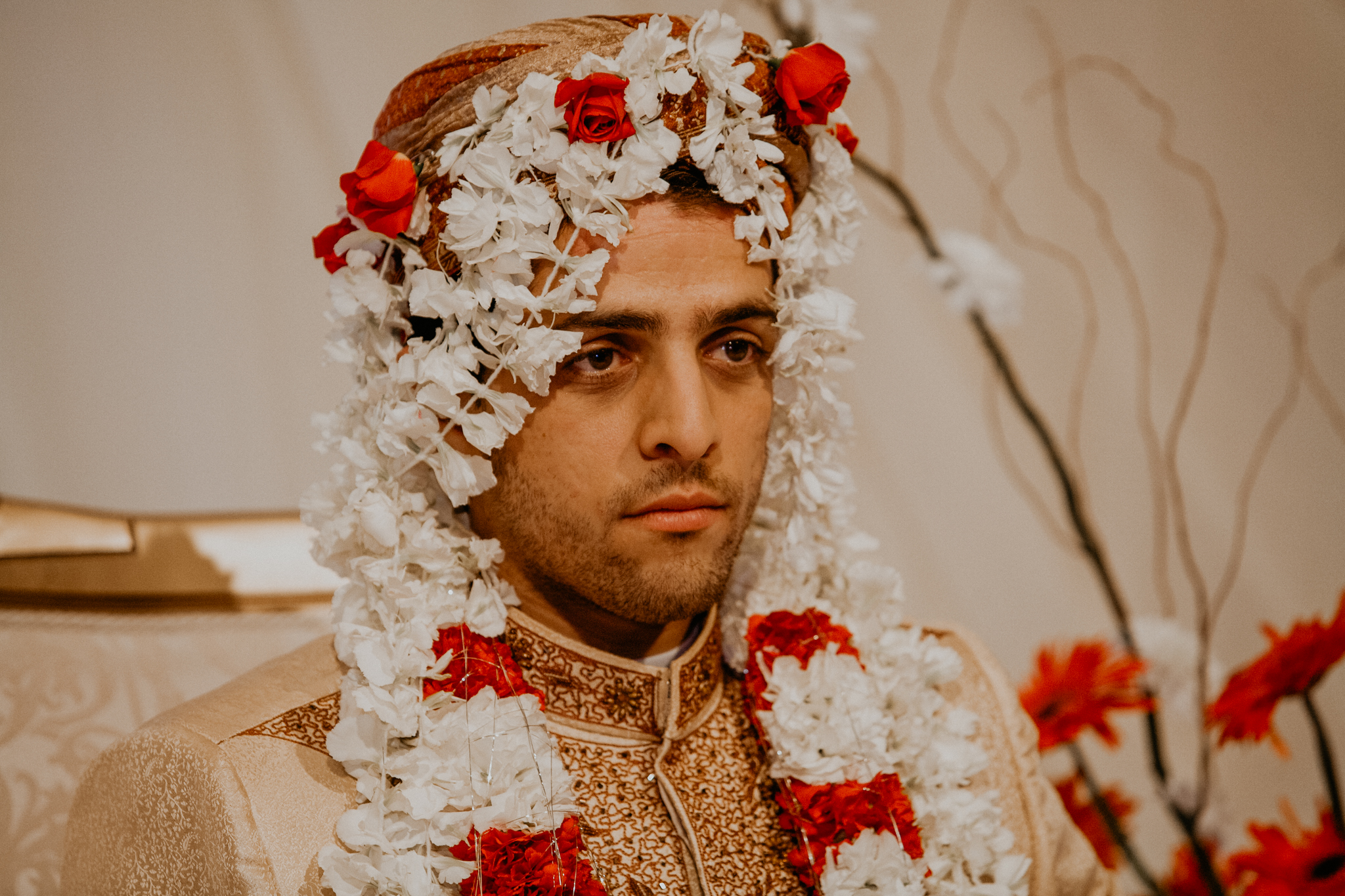 Indian groom with flower veil at Mehndi wedding