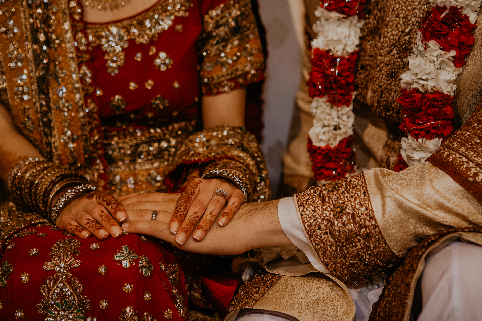Close up of rings and bride and groom hands Indian wedding ceremony