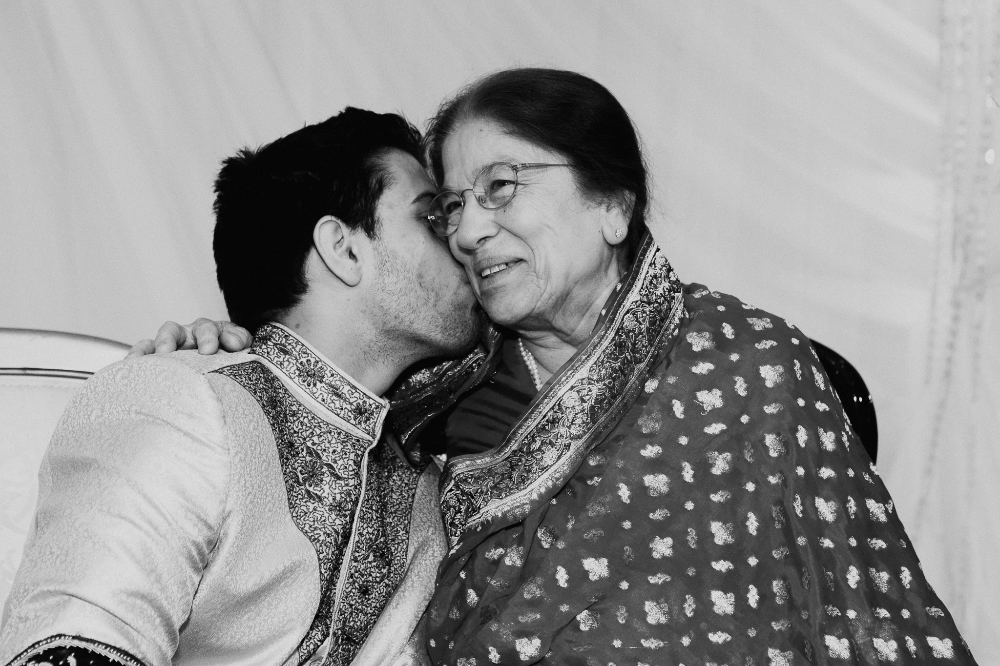 Groom kisses guest during Mehndi Indian wedding MN documentary wedding photo