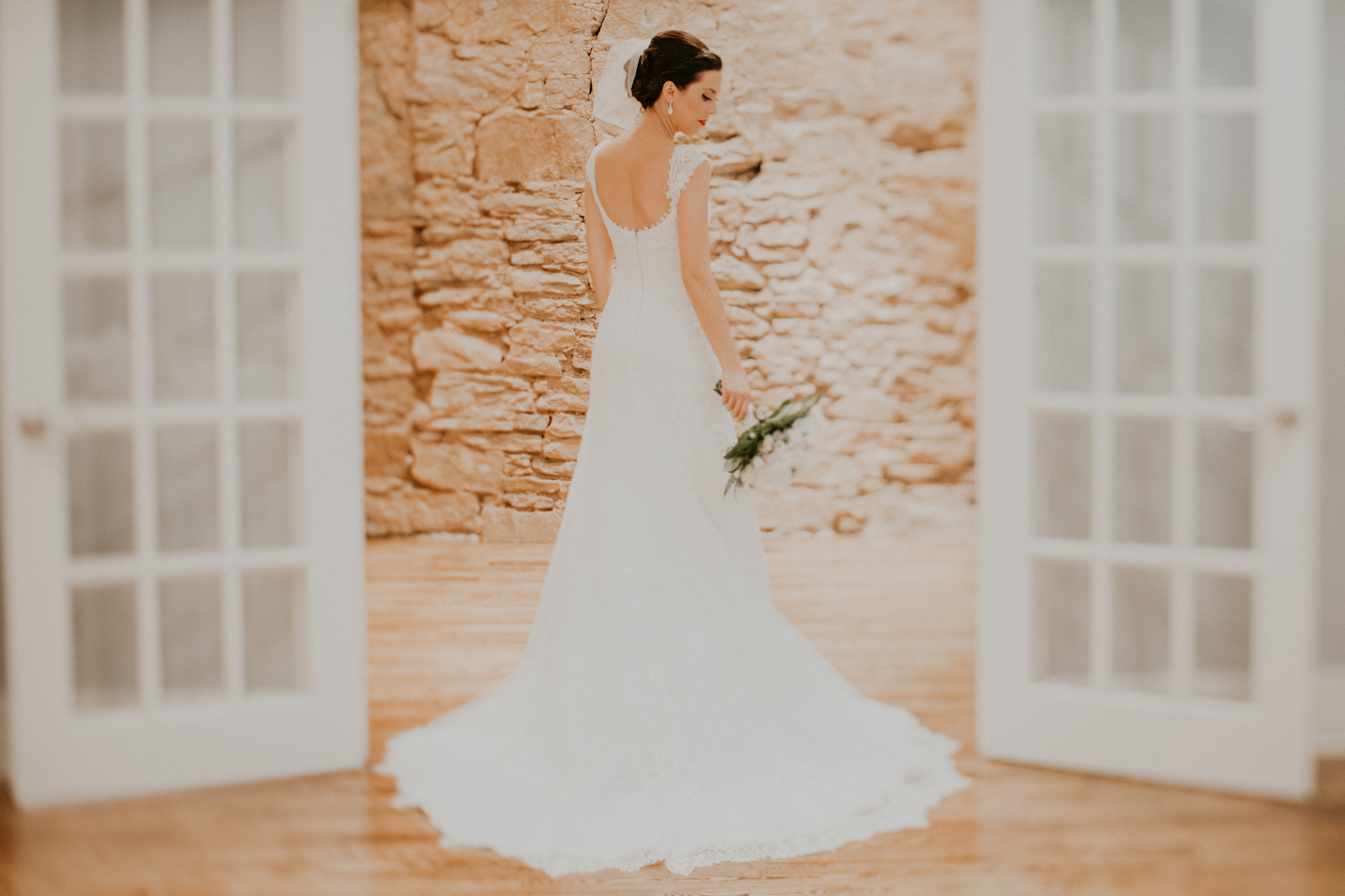 Portrait of bride in wedding dress framed by doorway