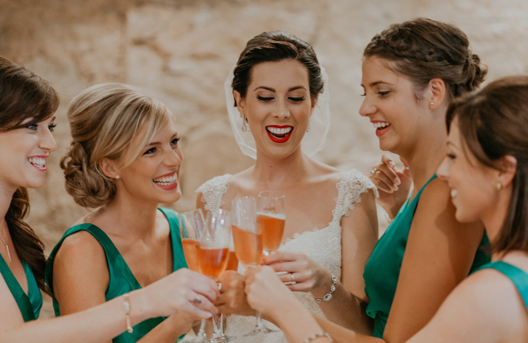 Bride and bridesmaids smile during champagne toast documentary wedding photograph