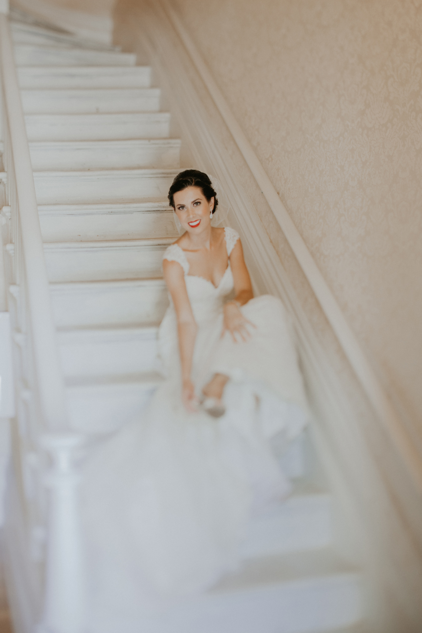 Portrait of bride on stairs putting on shoes