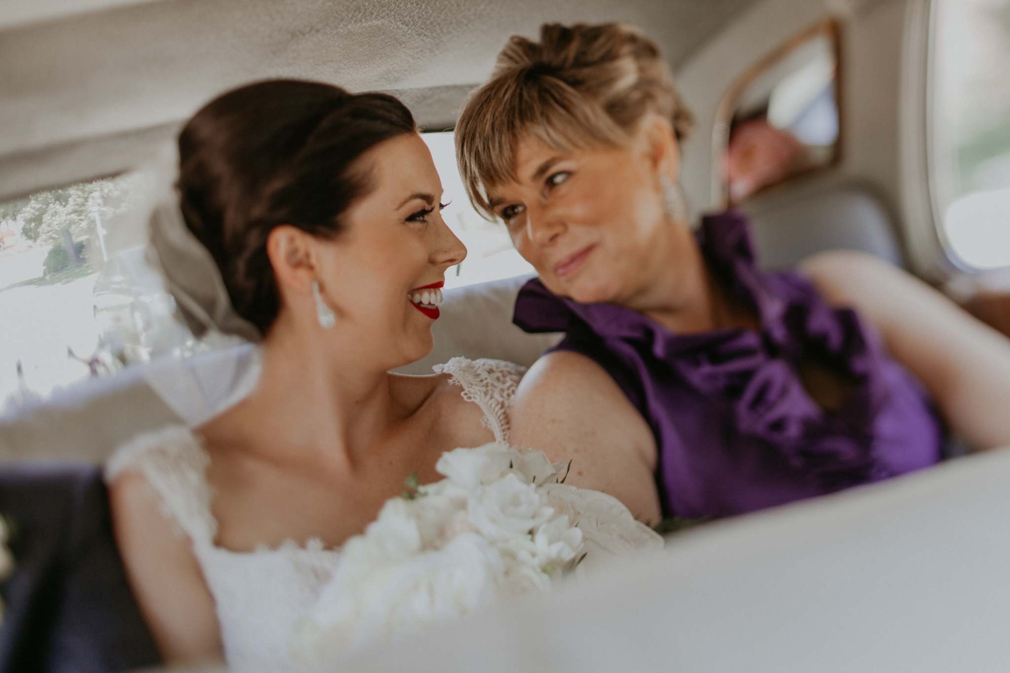 Bride and mother of bride smile at each other