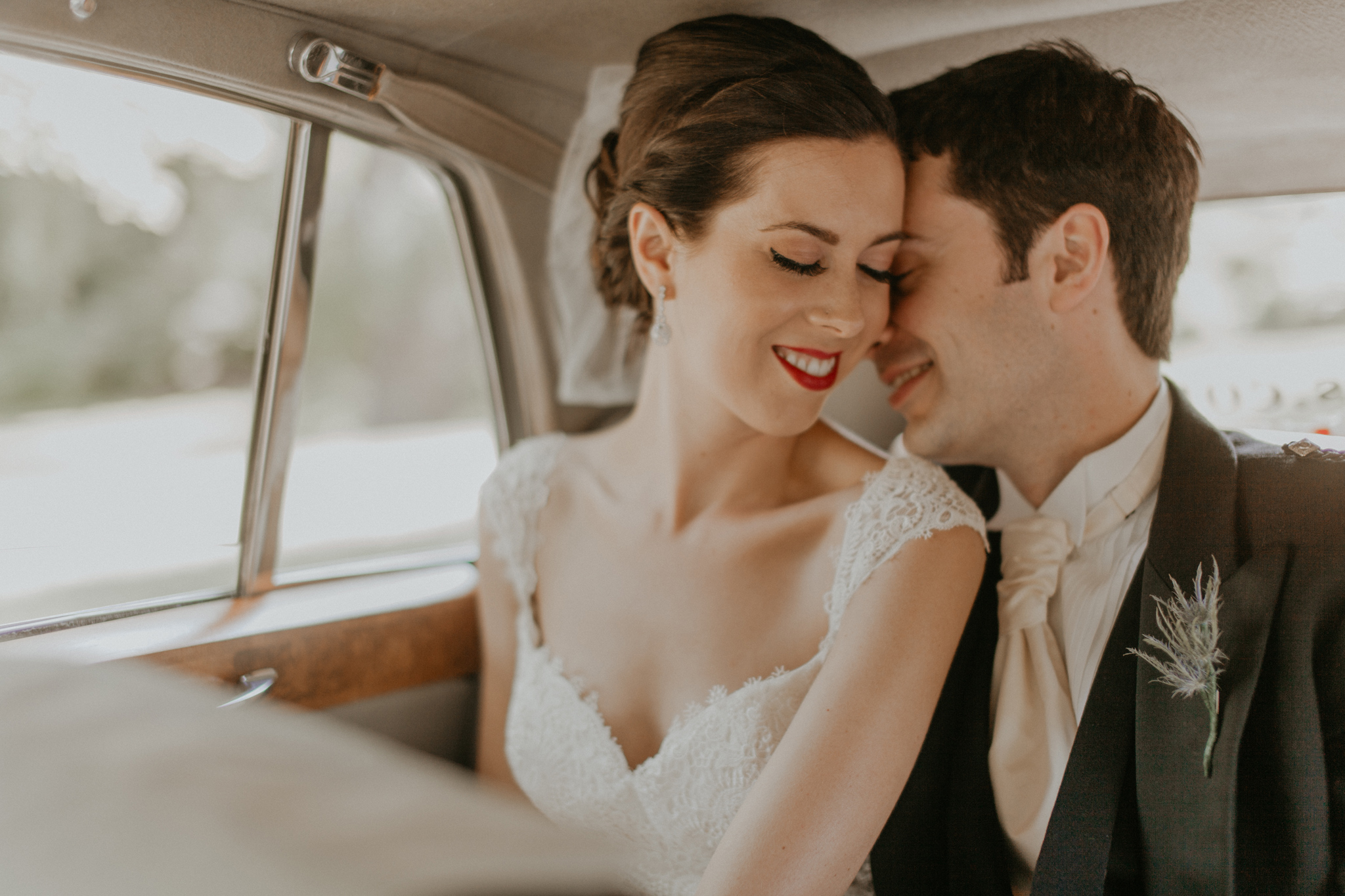 Bride and groom romantic photo in car on wedding day