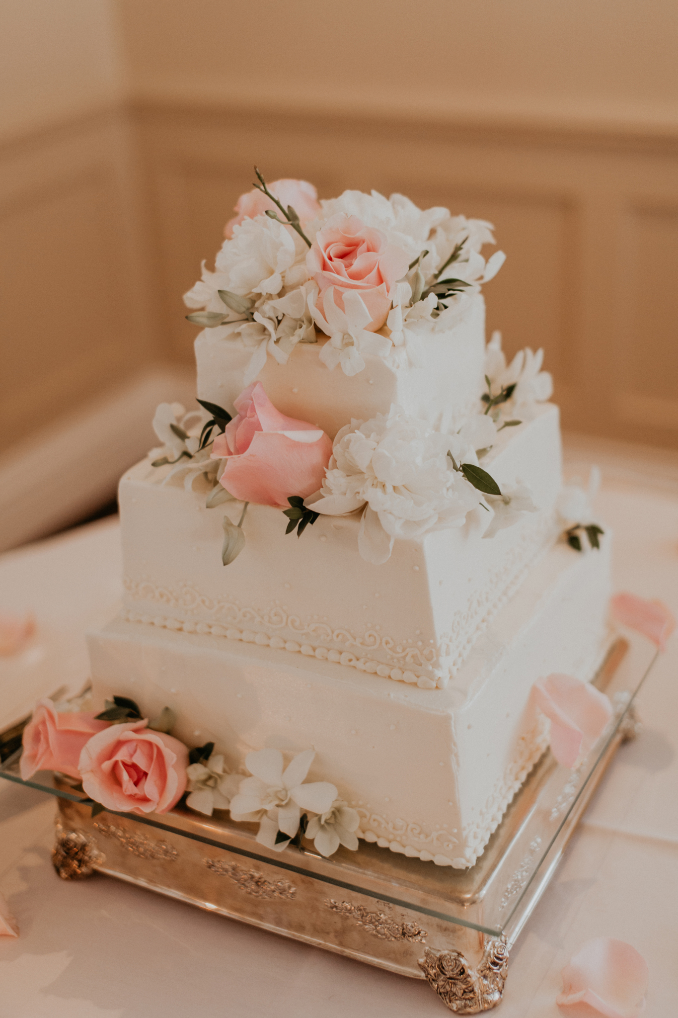 Wedding cake on table with pink roses