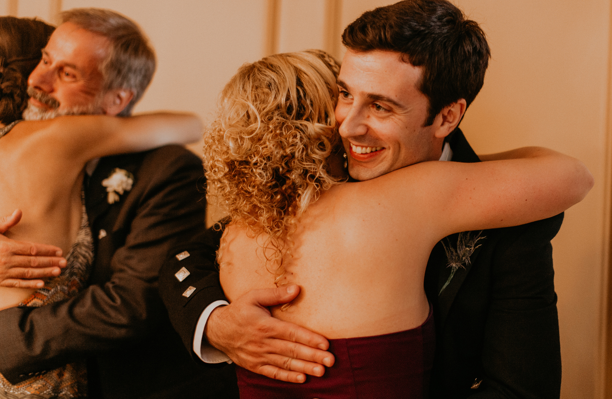 Groom hugs guest at wedding in candid photo