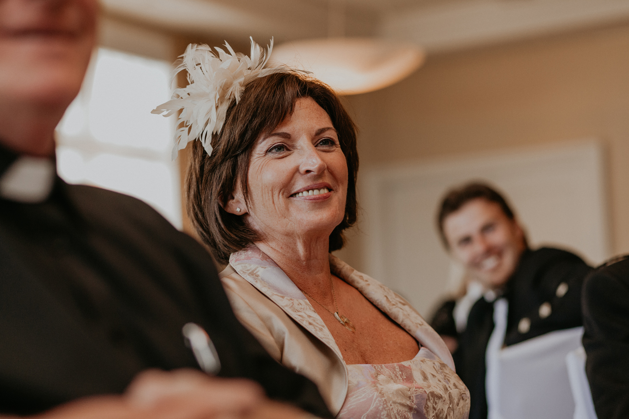 Mother of groom smiles during speeches at reception