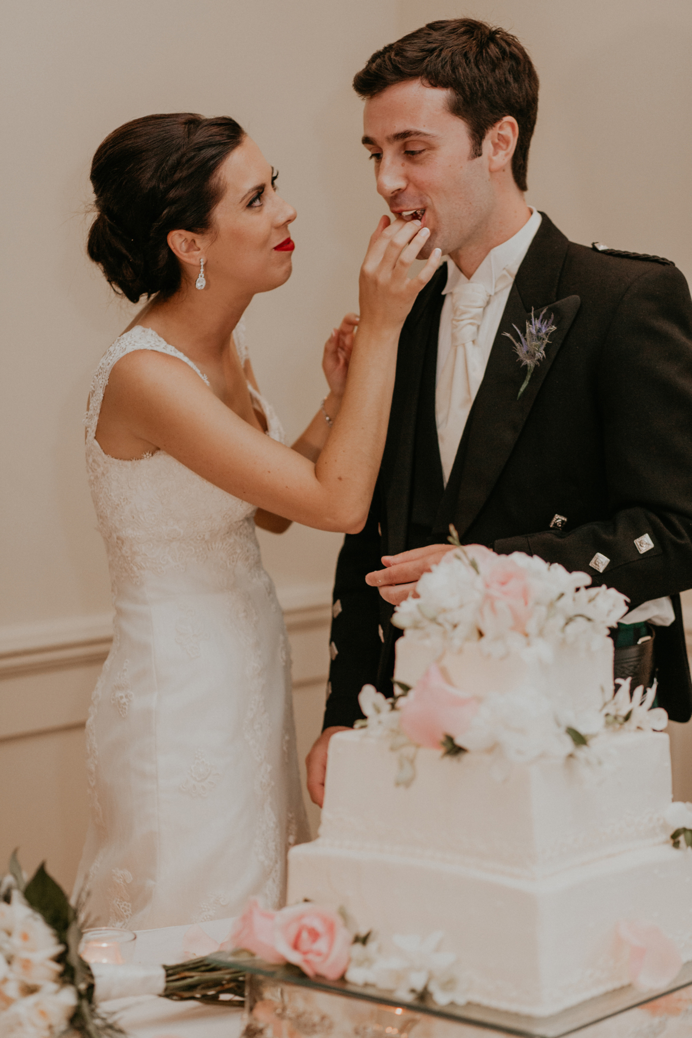 Bride feeds groom cake at wedding