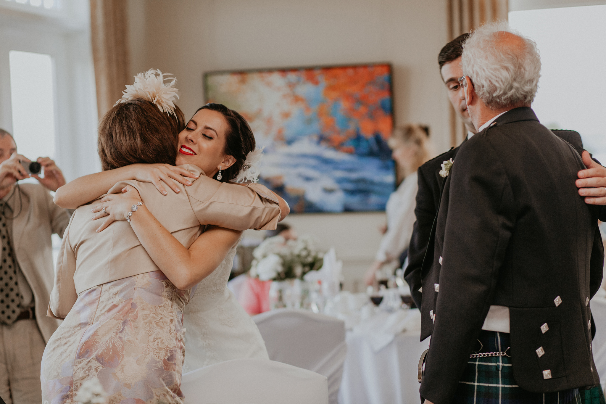 Couple embraces parents after speeches at wedding reception