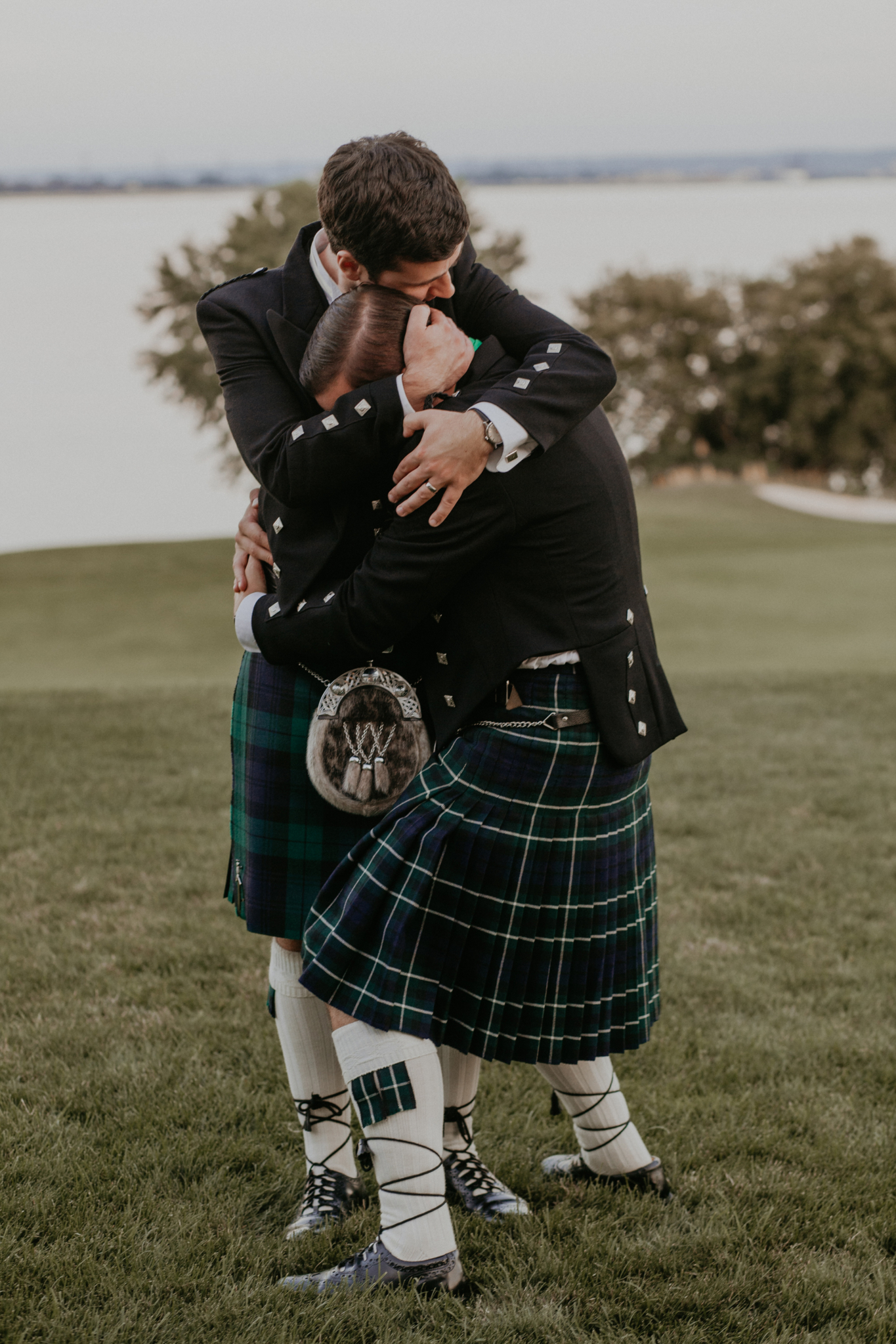 Documentary wedding photo candid of groom with best man hugging