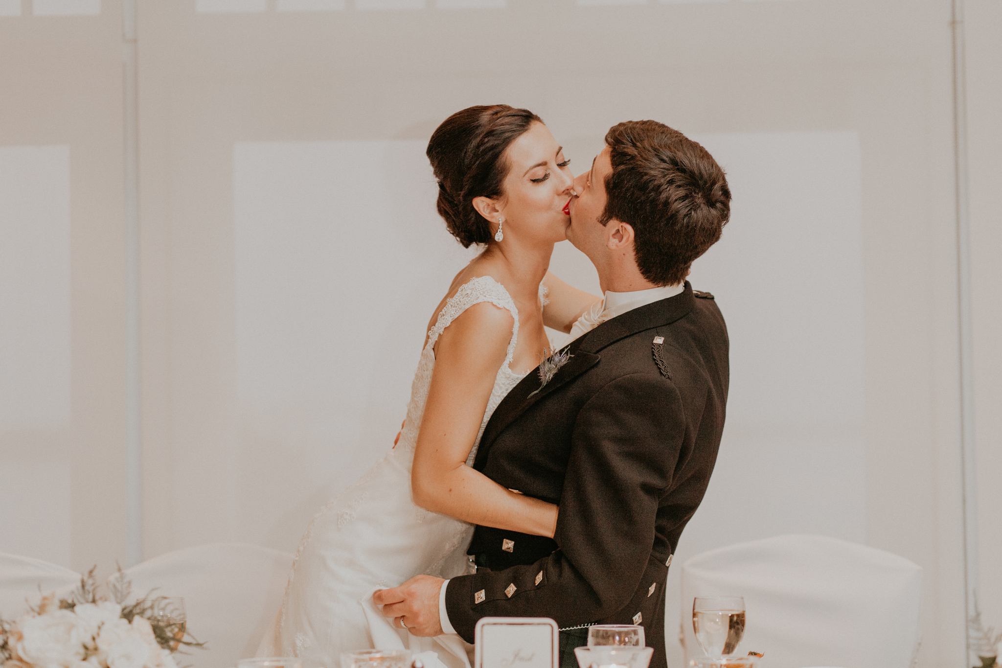 Bride and groom kiss during wedding reception