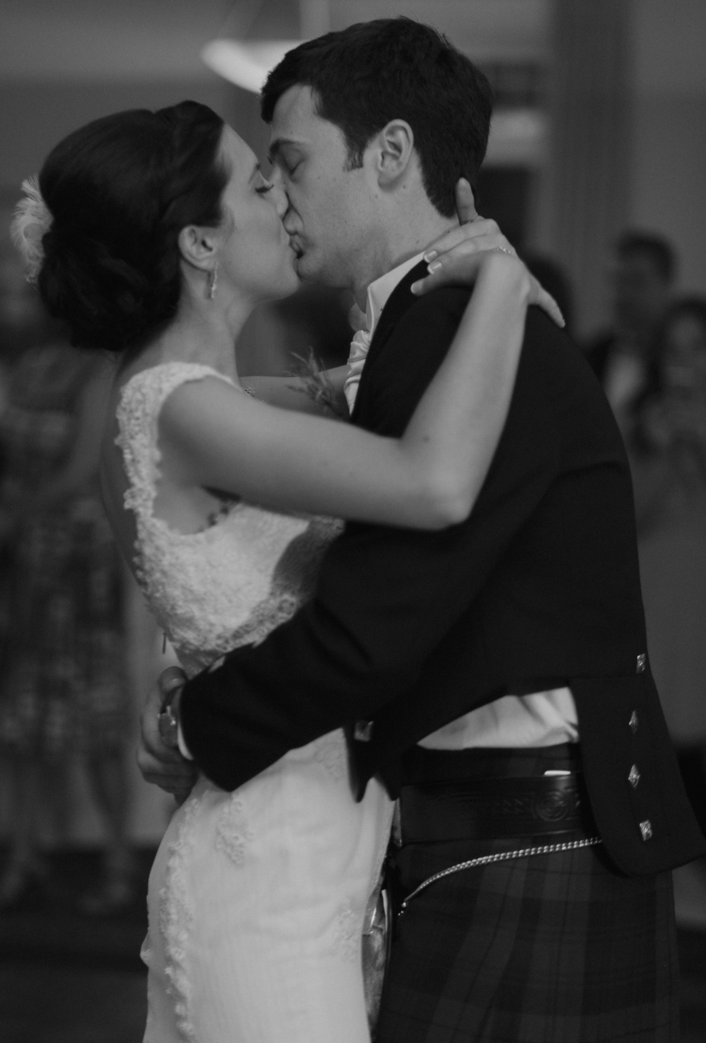 Candid photo of bride and groom kissing during first dance documentary wedding picture
