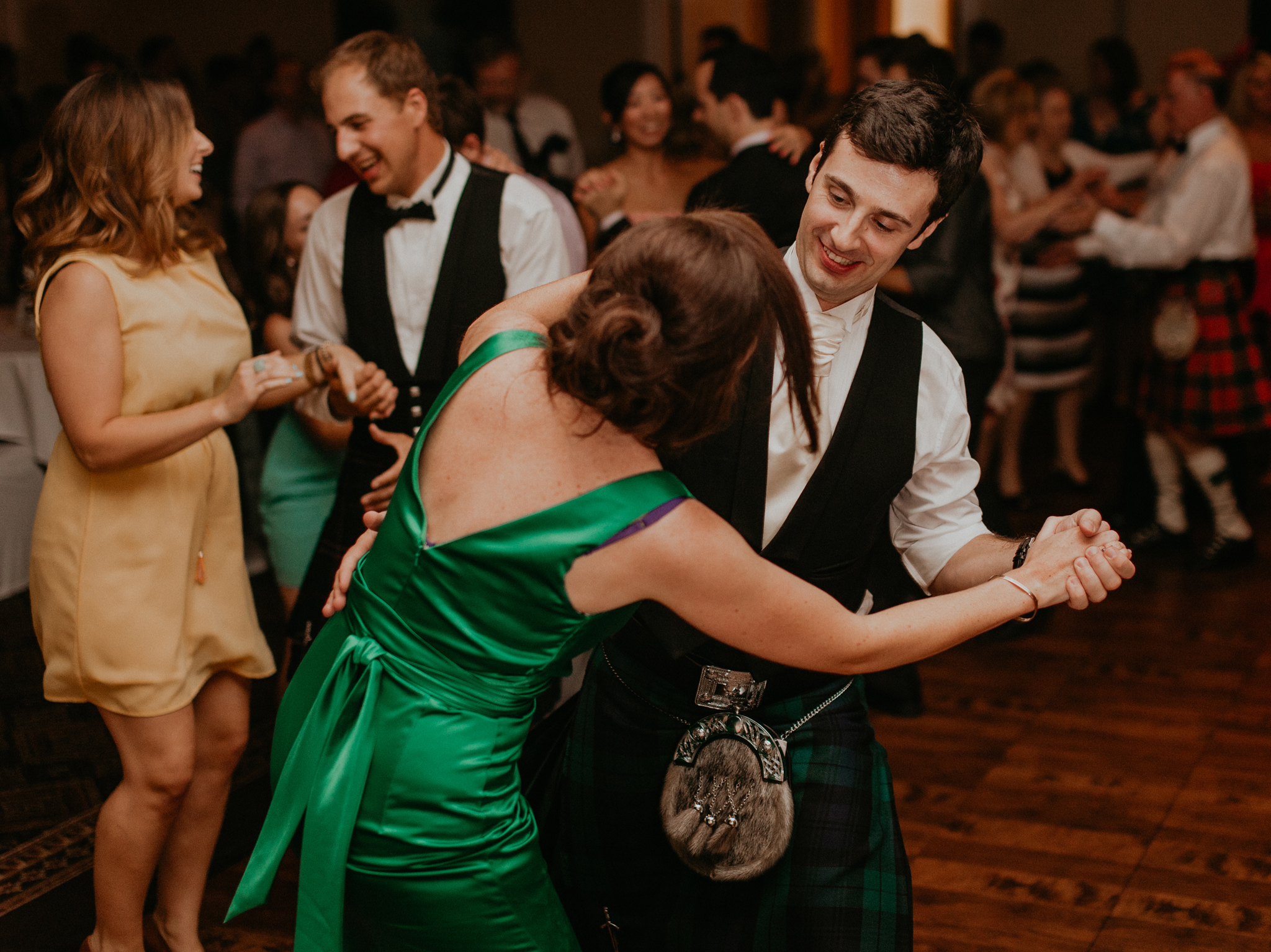 Groom dances with bridesmaid at wedding reception candid documentary photograph