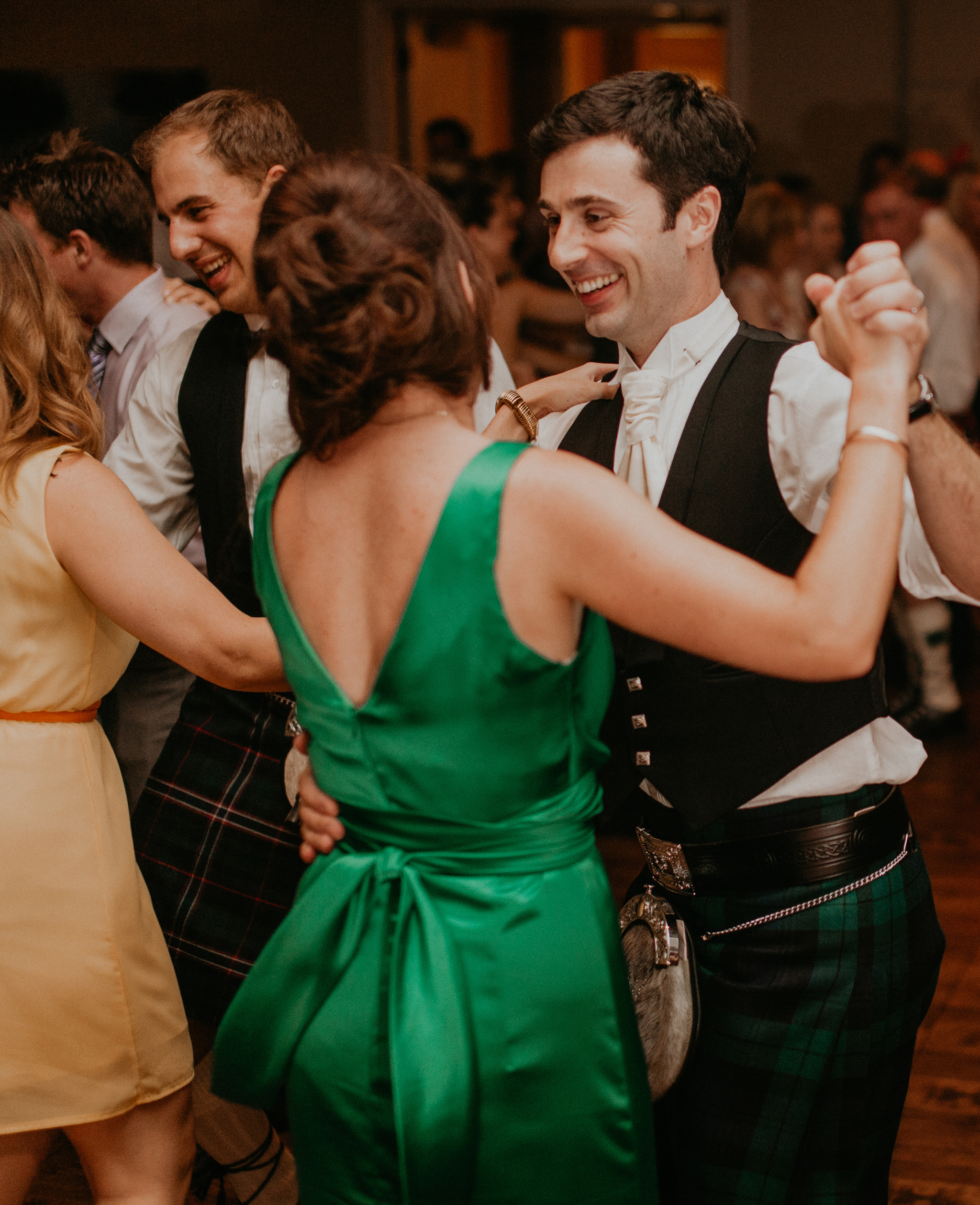 Groom dances with bridesmaid at wedding reception candid documentary photograph