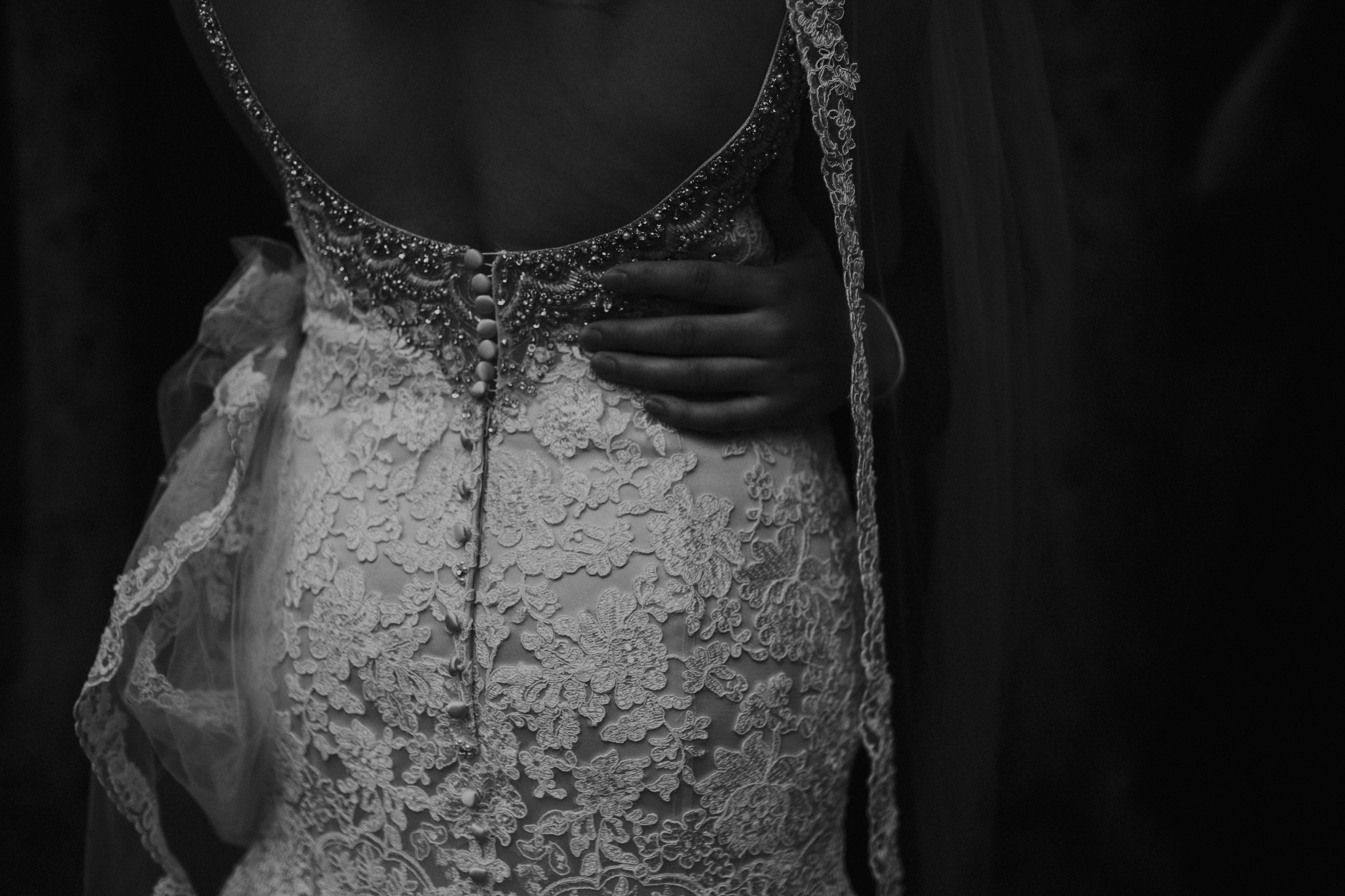 Black and white photo of groom's hand on bride's back moody photo