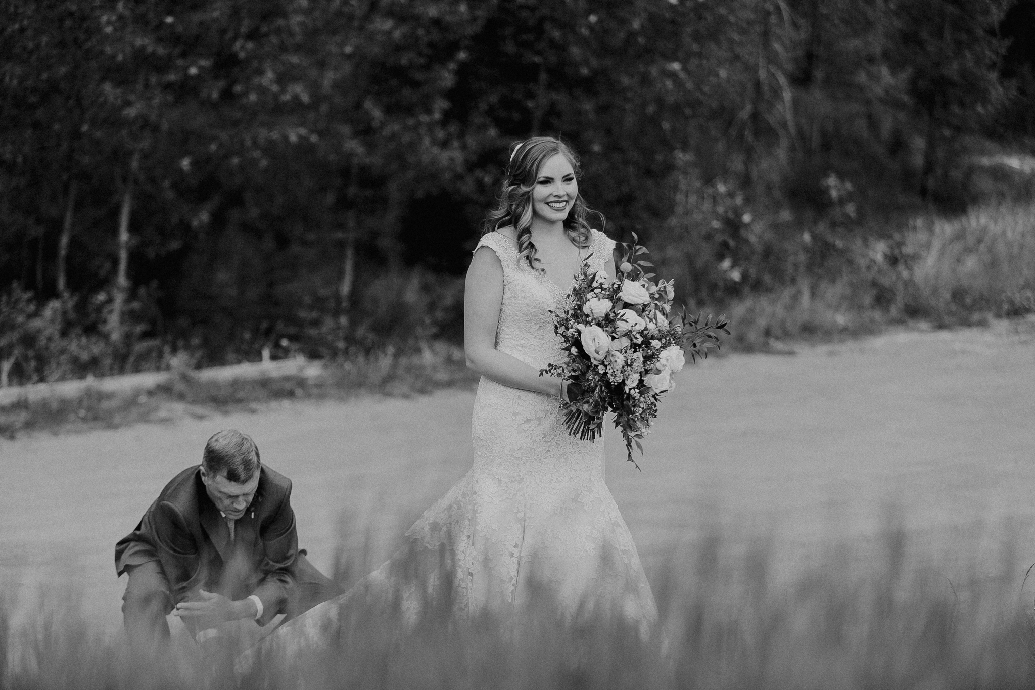 Father fixes brides dress at Silvertip Resort Canmore Alberta wedding ceremony