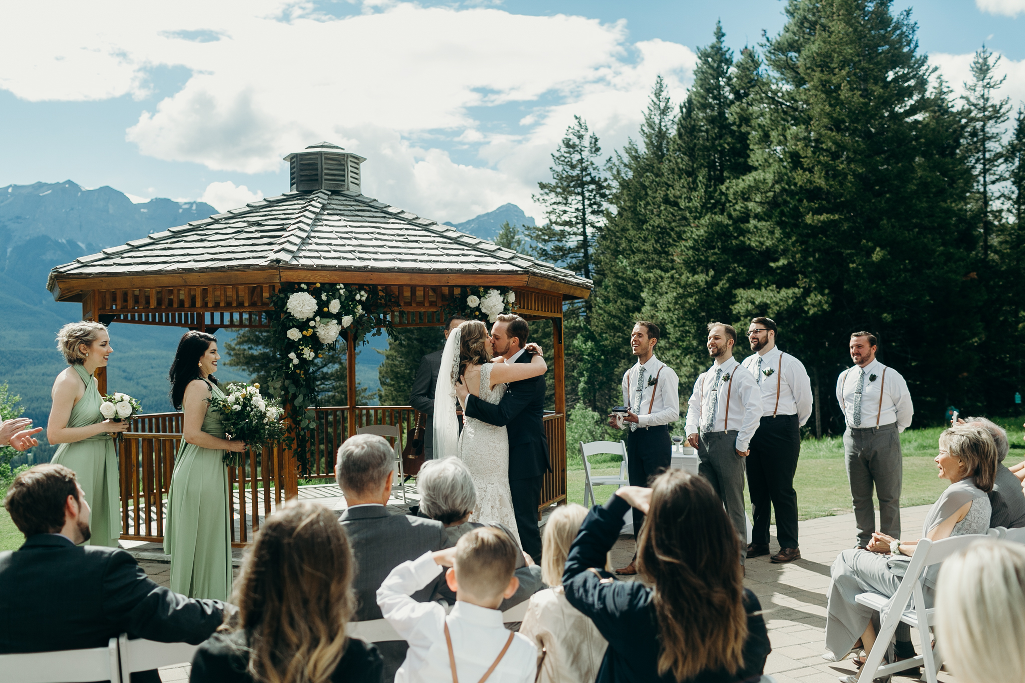 Bride and groom kiss at Silvertip Resort in front of gazebo and mountains