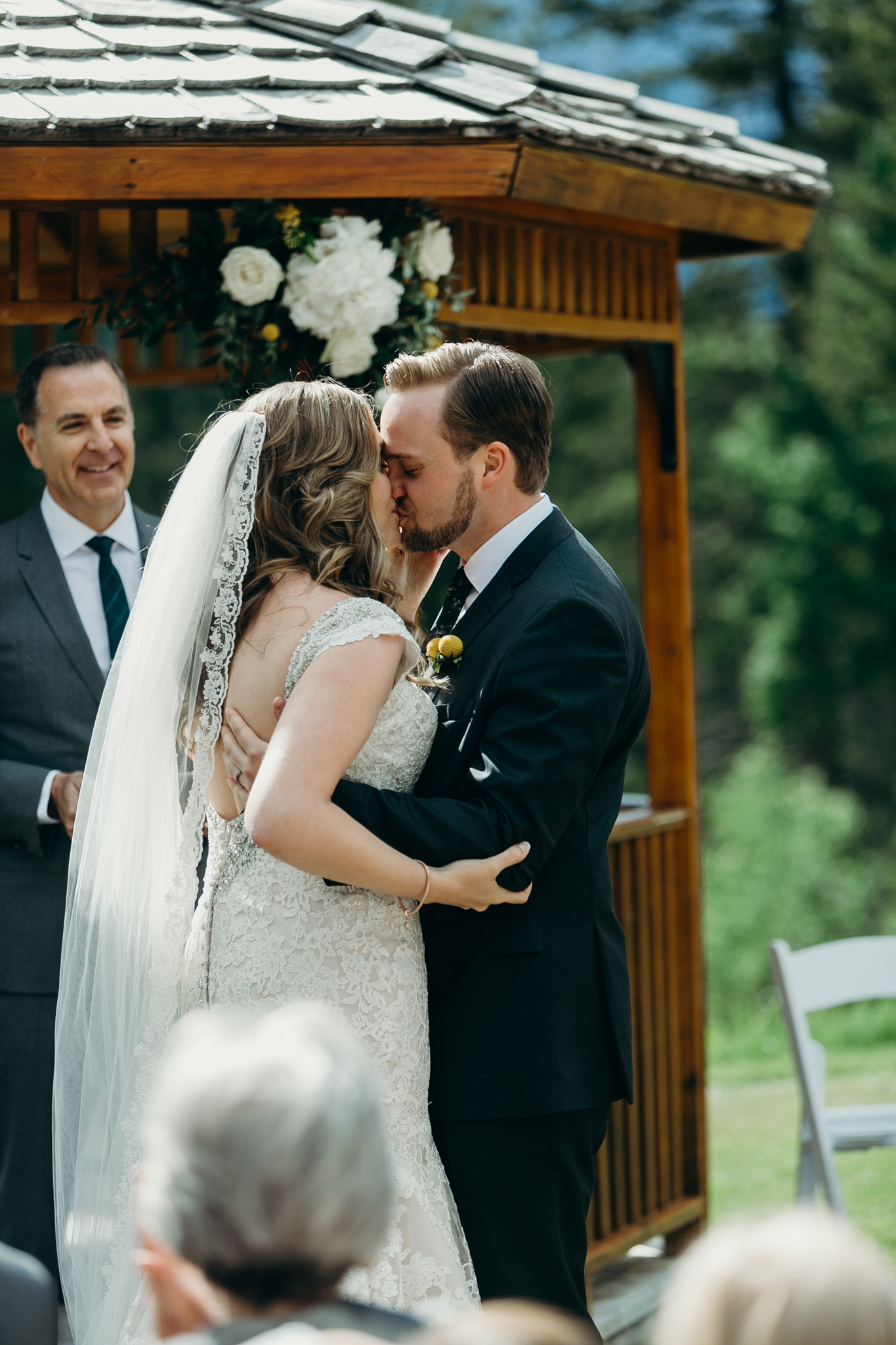 Bride and groom kiss at Silvertip Resort in front of gazebo and mountains