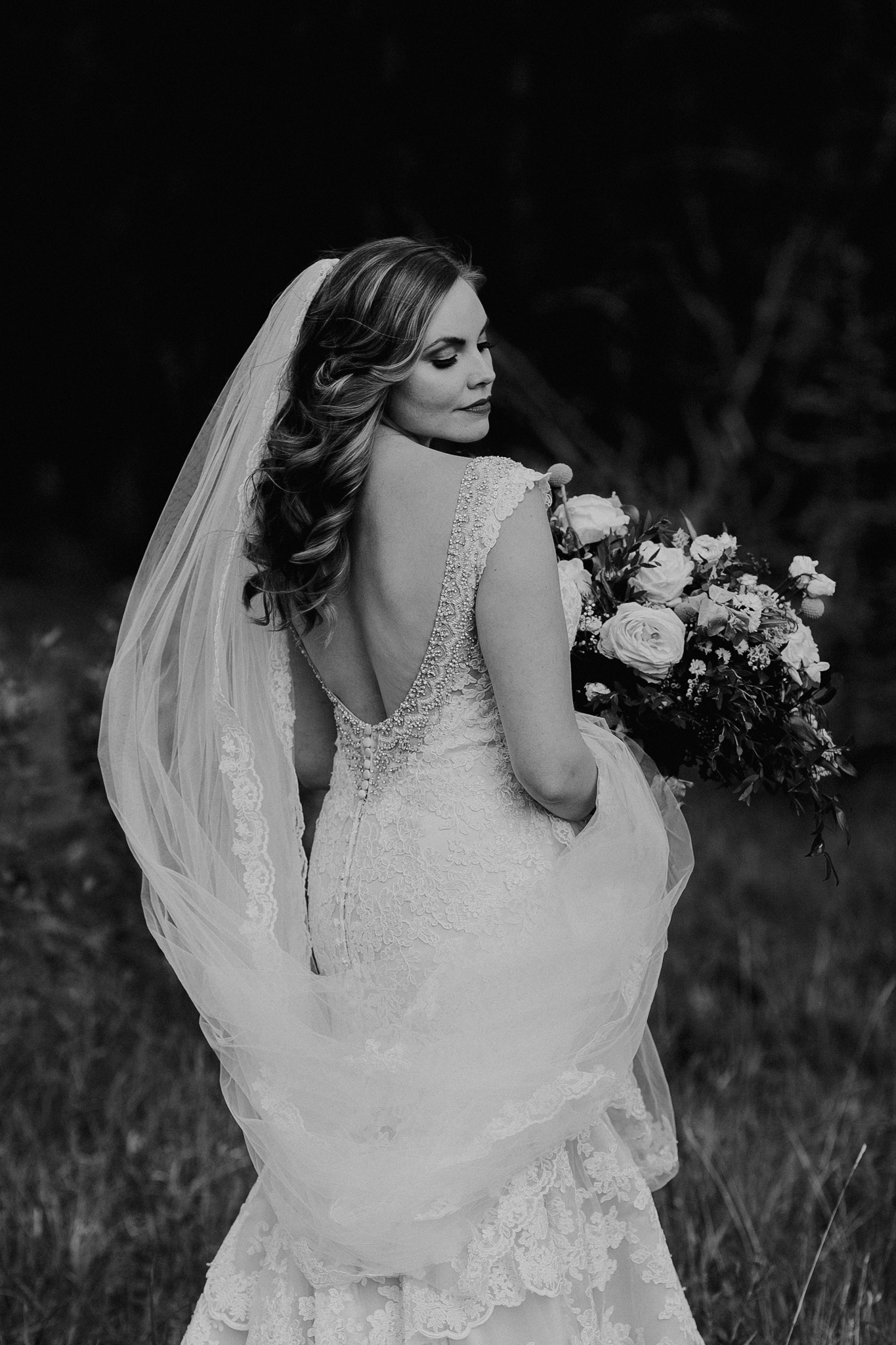 Bride poses for photo in black and white portrait at Silvertip Resort Canmore destination wedding