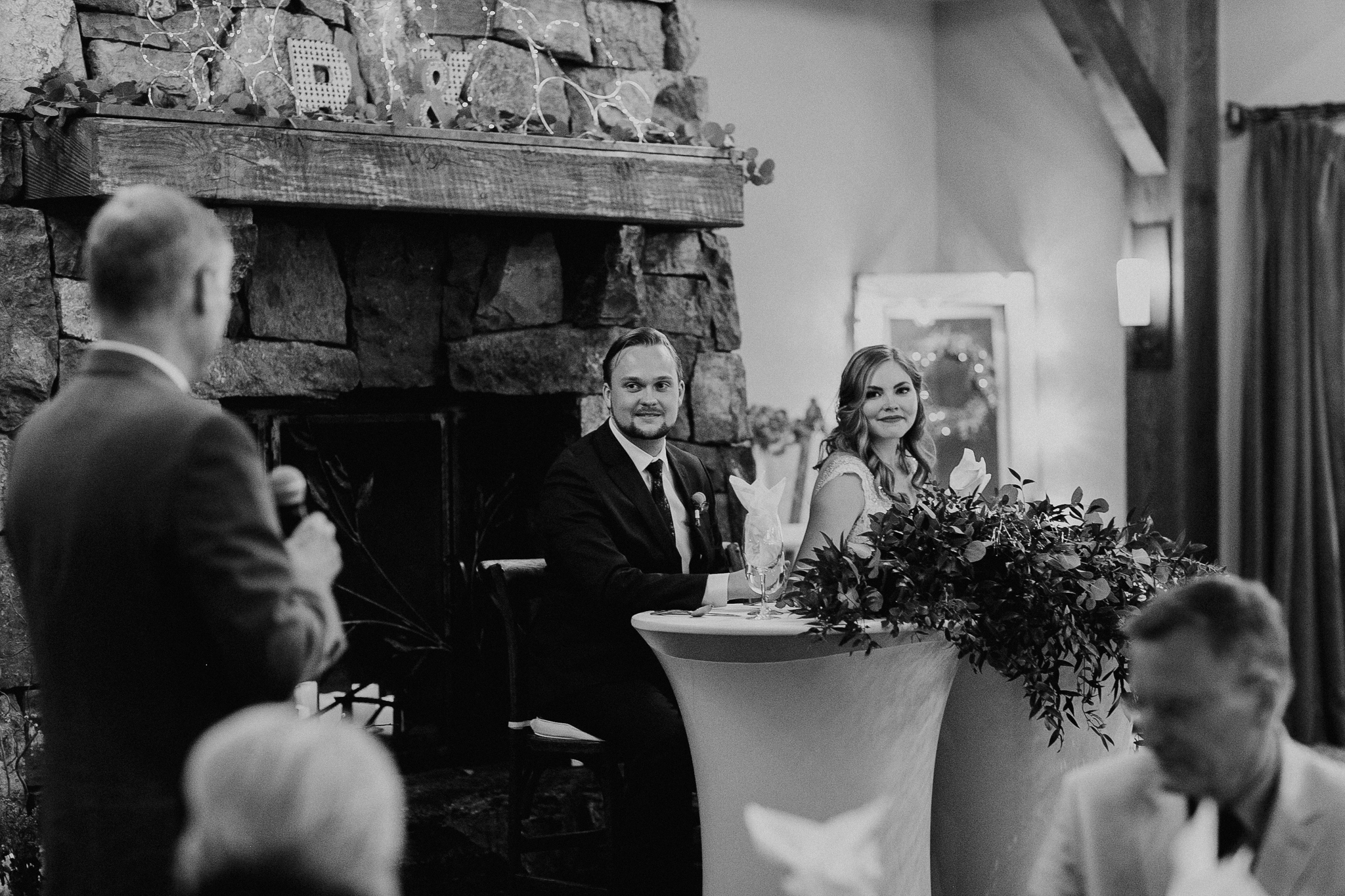 Bride and groom listen to speeches at Silvertip Resort wedding reception