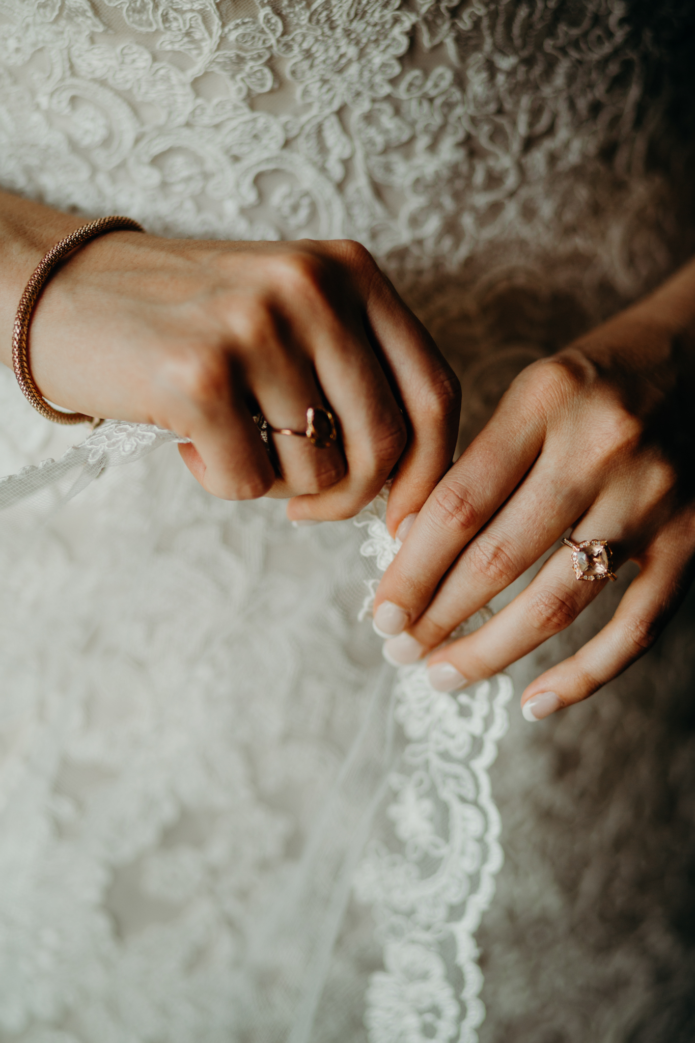 Close up of bride's hands fixing veil 