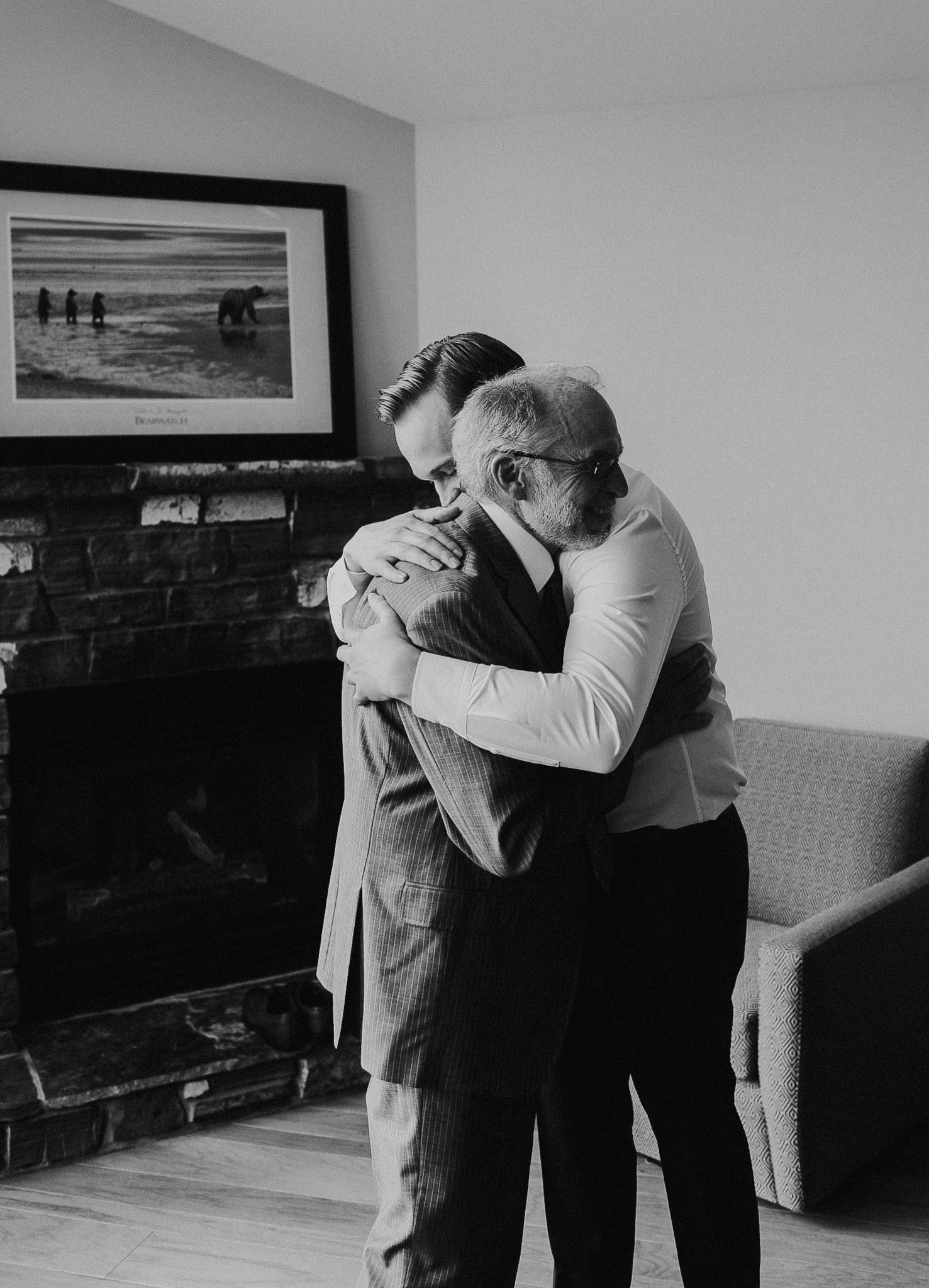 Groom and father hug documentary wedding photographer Minneapolis