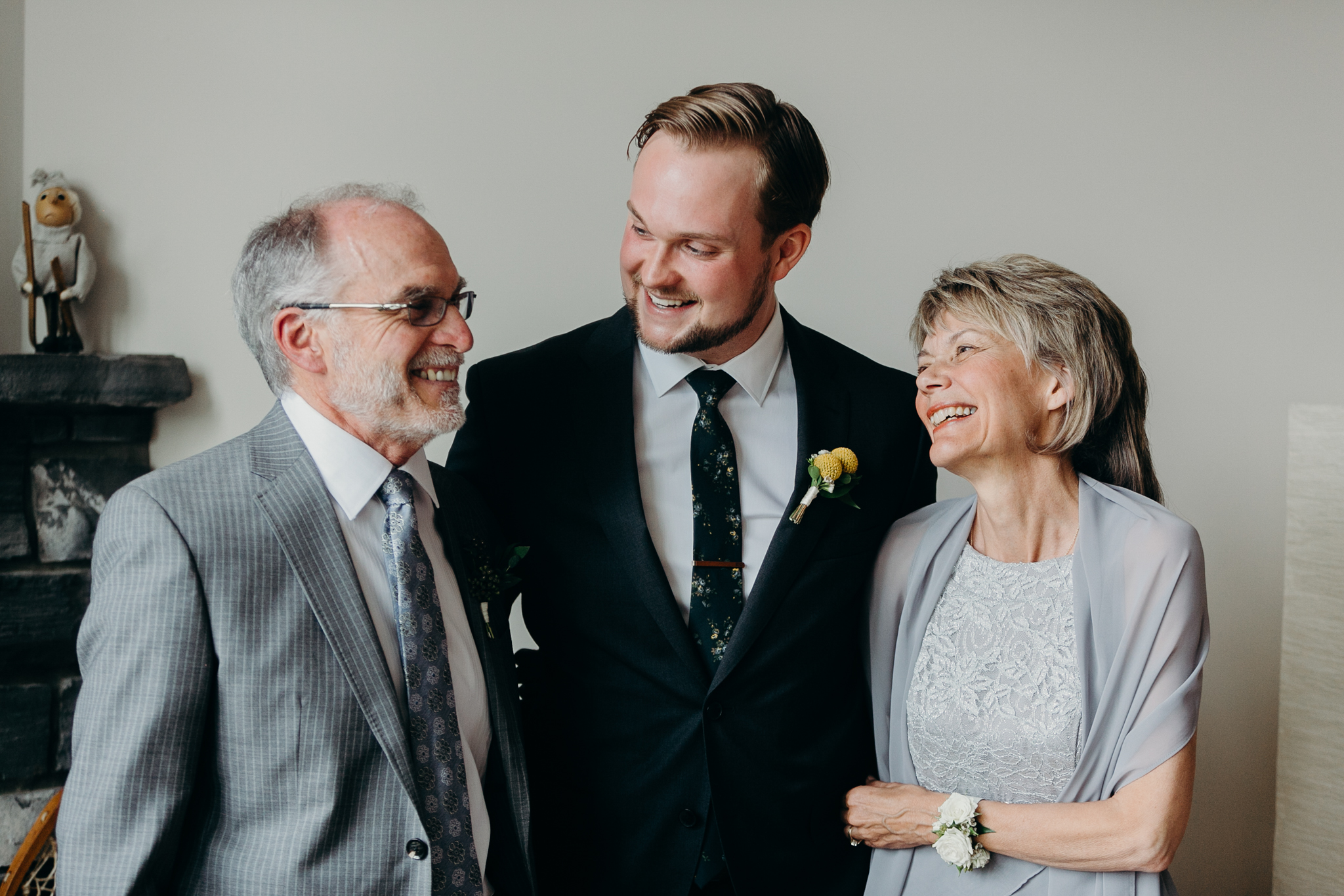 Portrait of groom looking at his father and mother before wedding candid MN wedding photographer