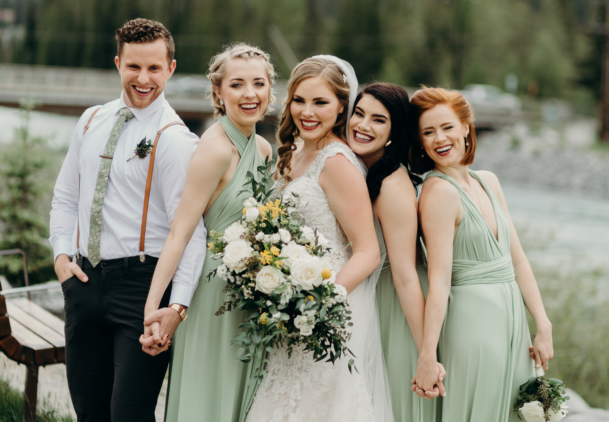 Bridesmaids post by river in green dresses