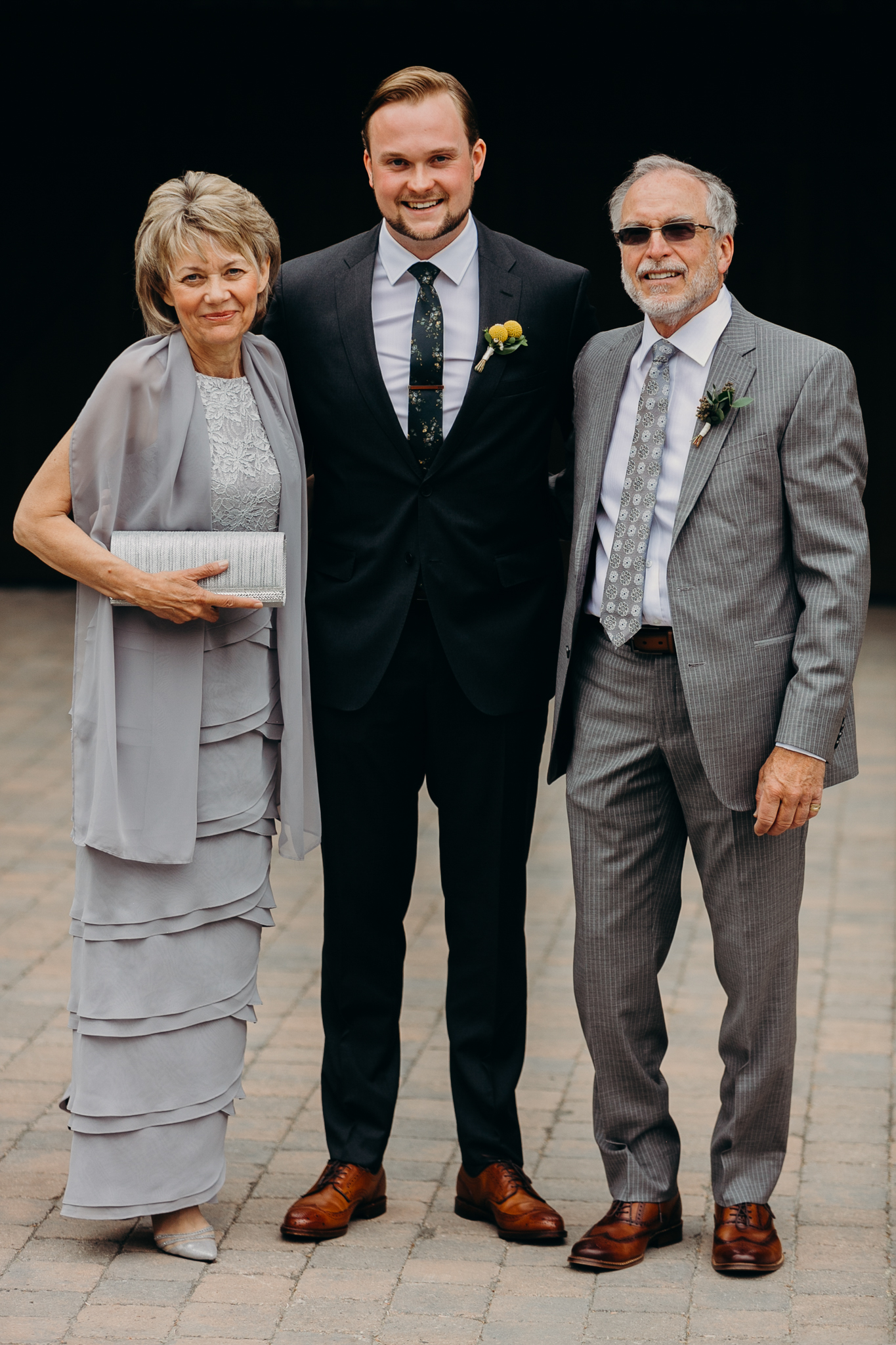 documentary wedding photograph of groom with mother and father Canmore Alberta